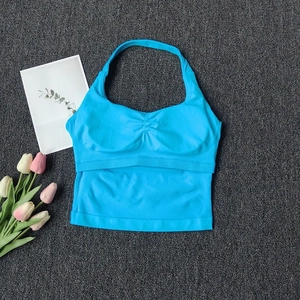 Detail of sky blue halter neck sports bra featuring center ruched fabric and wide hem