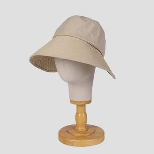 Beige wide brim sun hat for women with woven texture on a wooden mannequin head