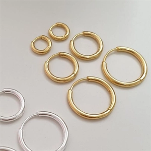 Detail showing various sizes of minimalist S925 sterling silver hoop earrings in gold and silver