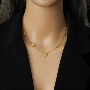 Elegante goldene Titan-Halskette mit Kleeblatt und weißen Strasssteinen am Model
