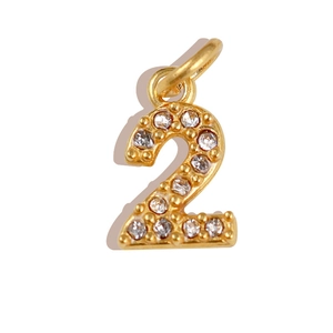 Detailed close-up of golden number 2 pendant featuring micro-pave white rhinestones