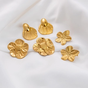 18K gold plated titanium steel flower and shell stud earrings on white silk fabric