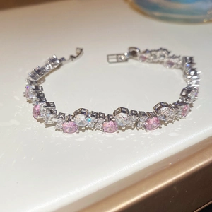 Macro detail of silver tennis bracelet featuring alternating pink and white zircons