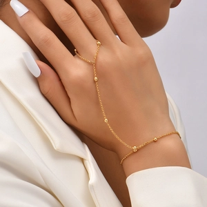Elegant gold finger bracelet chain with star and butterfly sequins and small beads on hand