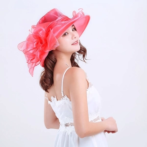 Detail shot of the red organza sun hat featuring a large floral side ornament on a model