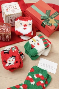 Detailed view of warm Christmas coral fleece socks in a festive holiday gift arrangement