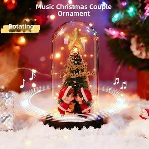 Detail of Christmas music box featuring a romantic couple and glowing tree in snow