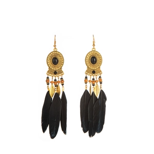 Close-up of black feather tassels and gold beads on bohemian vintage drop earrings