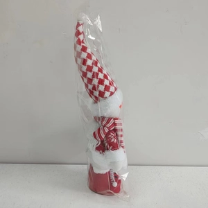 Detail of Christmas gnome plush with long red and white knit hat and snowflake pattern