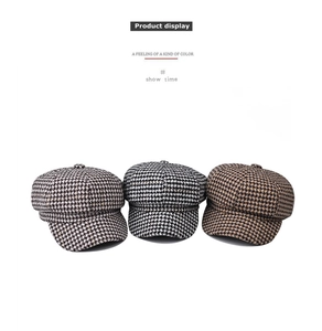 Detailed view of houndstooth newsboy caps in khaki, black-grey and brown colors
