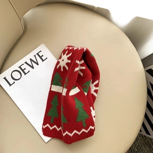 Detail of red knitted scarf with green Christmas trees and soft wool texture for kids