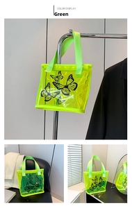 Close-up of neon green transparent PVC tote bag with black butterfly print