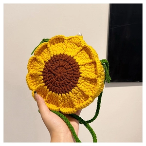 Close-up of handmade sunflower crochet bag with green strap and pearl button detail