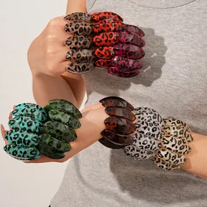 Leopard print acrylic hair claws in multiple colors shown on arm for size and variety