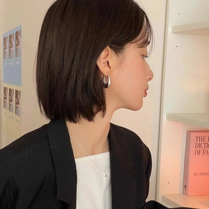 Minimalist silver water drop hoop earrings and star necklace shown on a model