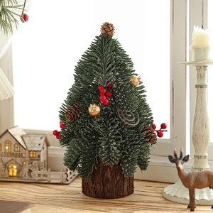 Mini artificial green Christmas tree with red berries and pine cones on a wooden base