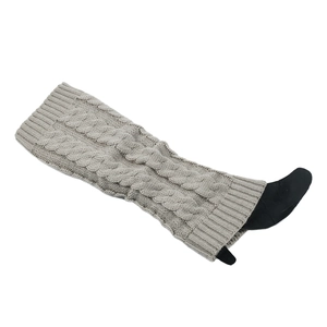 Detail of grey knitted leg warmers showing thick cable knit texture and elastic cuffs