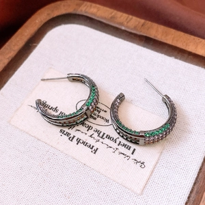 Close-up of vintage C-shape earrings with multi-color zircons in gun black plating