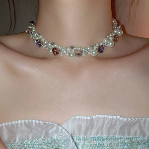 Detailed close-up of multilayer pearl necklace with heart-shaped gems and sparkly crystals