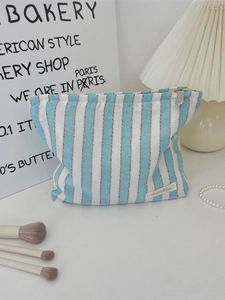 Minimalist blue striped canvas tote bag with zipper closure and brand label for women