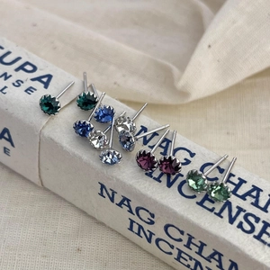 Macro shot of assorted colorful S925 sterling silver birthstone stud earrings on a box
