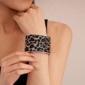 Detail of grey leopard print velvet texture and silver metal edges on wide open cuff bangle