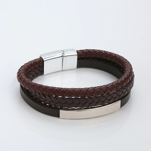 Detail of multi-layer brown braided leather bracelet with a polished silver magnetic clasp