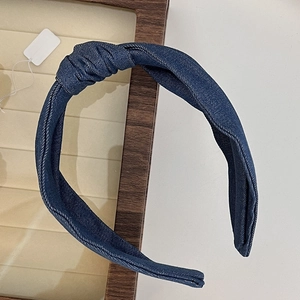 Close-up of blue denim knotted headband texture and fabric detail on a display tray