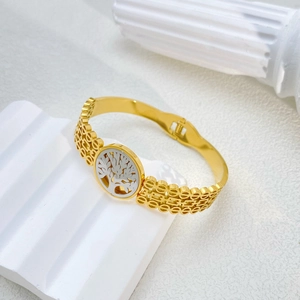 Detailed close-up of tree of life engraving on a two-tone gold and silver steel bangle
