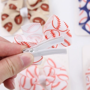 Detailed back view of a baseball print bow hair clip showing the secure fabric-wrapped metal grip