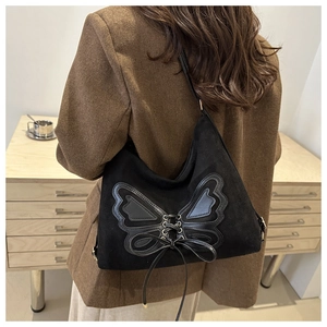 Close-up of black suede tote bag with butterfly embroidery and bow drawstring detail
