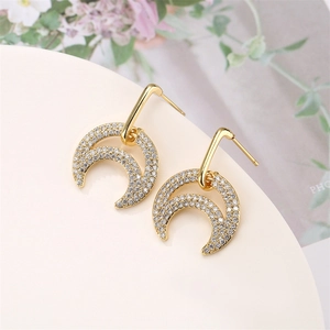Macro shot of gold crescent moon earrings with micro-paved cubic zirconia stones