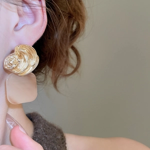 Close-up of retro square acrylic pendant earrings on model with golden shell texture