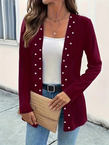 Close-up of elegant burgundy knit cardigan with vertical texture and pearl bead embellishments