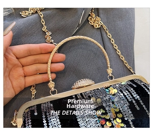 Close-up of golden hollow carved handle and sparkling rhinestones on sequined evening bag