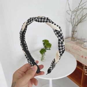 Detail of hand-held braided headband featuring black and white houndstooth pattern