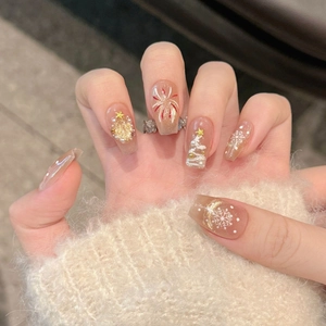 Close-up of Christmas themed press-on nails with snowflakes and gold tree art