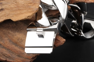 Macro shot of silver heavy-duty titanium steel link chain on a natural wooden background