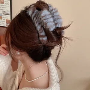 Pince à cheveux élégante en peluche rayée grise portée dans un style d'hiver cosy
