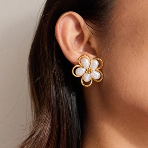 Detail of flower-shaped 18K gold stainless steel earrings with white pearls on a model