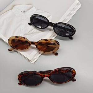 Flat lay of vintage oval sunglasses in black and tortoiseshell with 13042 frame details