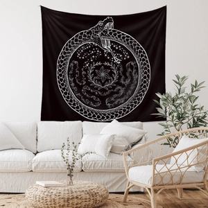 Detail of Ouroboros tapestry with stars and leaves patterns hanging on a white wall