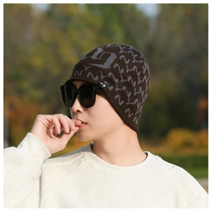 Detail shot of men's brown knit beanie and black sunglasses in outdoor winter setting