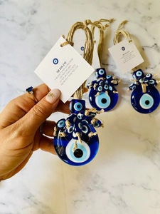 Detail of Turkish Evil Eye glass charms with blue amulets and protective English quote card