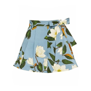 Detail view of high-waist floral shorts with white magnolia print and bow tie belt