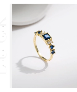 Macro detail of S925 sterling silver stamp on golden ring with blue square gemstone