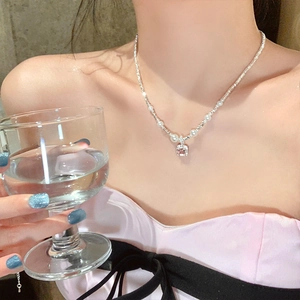Detail of pink square gemstone and pearl necklace worn by model in French elegant style