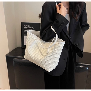 Close-up of white woven tote bag texture with smooth shoulder straps and modern minimalist design
