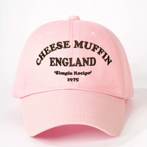 Close-up detail of Cheese Muffin embroidery on a pink cotton twill baseball cap