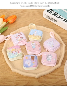Detailed view of colorful square tinplate coin purses and cable organizers on a tray
